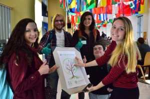 students holding a poster of a tree